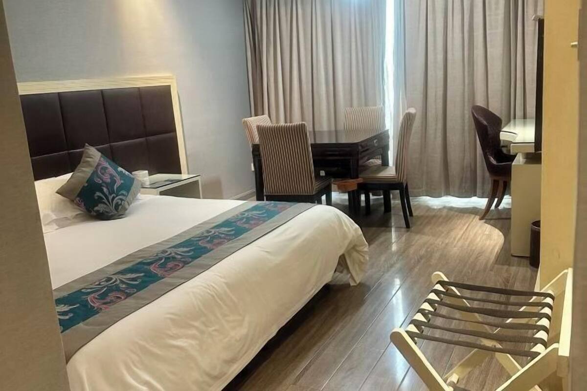 Une chambre d’hôtel comprenant un lit, un bureau, une chaise et une table à manger.