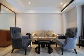 A modern living room with a sofa, two armchairs, and a coffee table. - Wisconsin Spa Hotel (Tianjin)