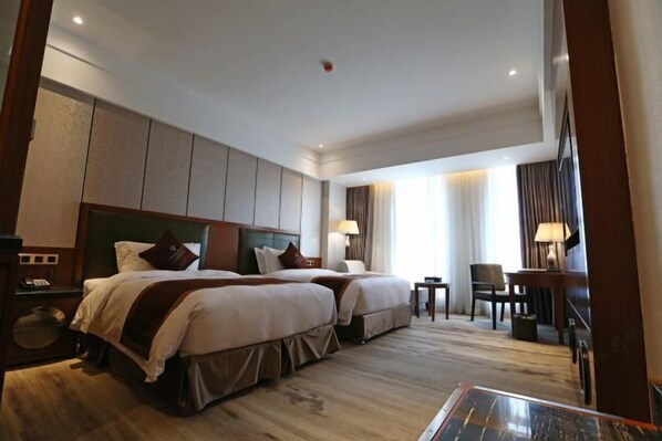 A hotel room with two beds, a desk, and a chair. - Wisconsin Spa Hotel (Tianjin)