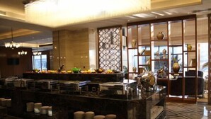 A hotel lobby with a buffet area, a decorative wall with geometric patterns, and a chandelier. - Wisconsin Spa Hotel (Tianjin)