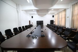 A conference room with a long table, chairs, a projector, and a whiteboard.