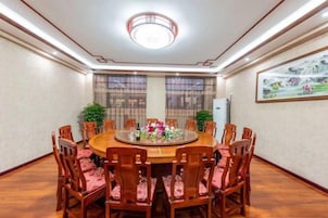 A conference room with a round table, chairs, and a ceiling light fixture.