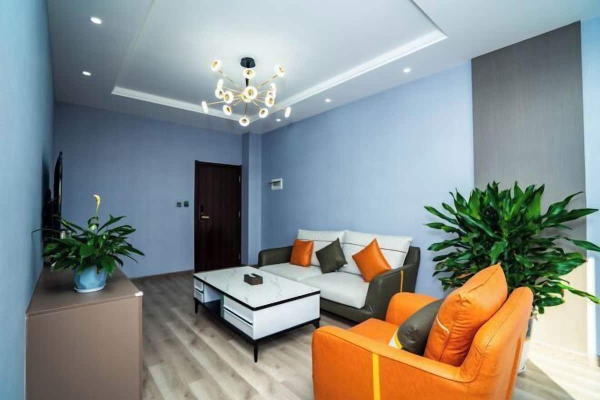 A modern living room with a sofa, coffee table, and potted plants.