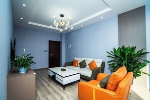 A modern living room with a sofa, coffee table, and potted plants. - Taowowo Holiday Hotel (Jianshui)