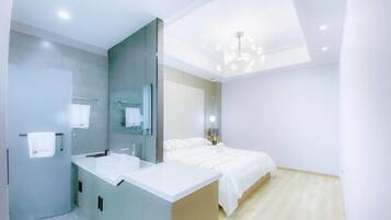 A modern bedroom with a bed, a vanity with a mirror, and a ceiling light fixture.