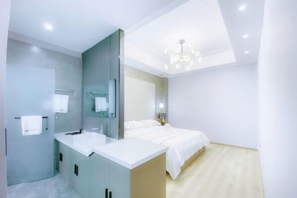 A modern bedroom with a bed, a vanity with a mirror, and a ceiling light fixture. - Taowowo Holiday Hotel (Jianshui)