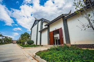 Un edificio de estilo arquitectónico tradicional, con un acceso mediante portón y un jardín bien cuidado.