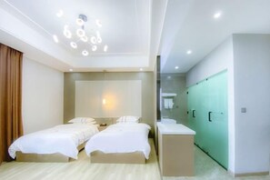A modern hotel room with two beds, a desk, a mirror, and a bathroom with a green door. - Taowowo Holiday Hotel (Jianshui)