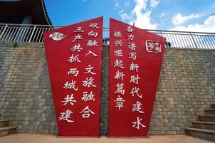 Two red banners with white Chinese characters against a brick wall.
