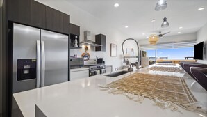 Una cocina moderna con refrigerador, estufa y lavamanos incorporados.