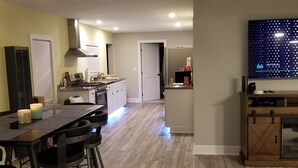 Una cocina moderna con comedor, un televisor de pantalla plana grande y un tapete acogedor.