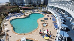 Ein Poolbereich mit einem herzförmigen Pool, Liegestühlen und einem Whirlpool.