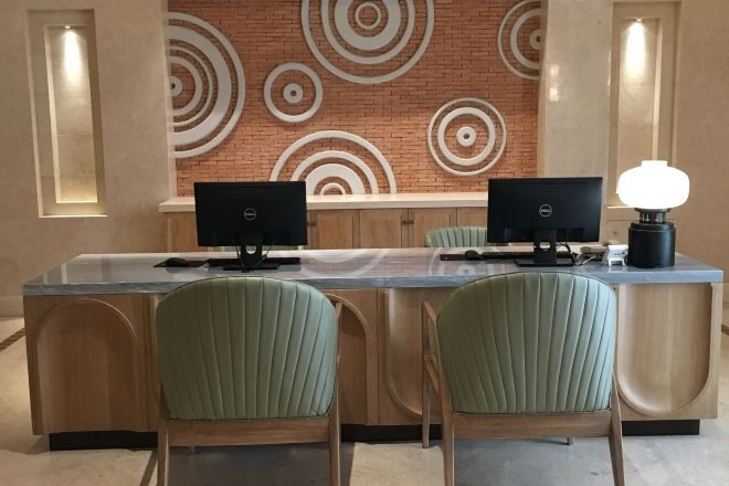 A conference room with a long table, two monitors, and three chairs.