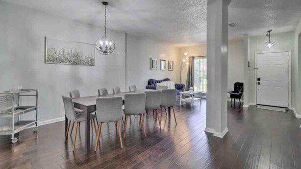 A spacious living room with a dining area, hardwood floors, and a chandelier. - Beckley's place (Jacksonville)