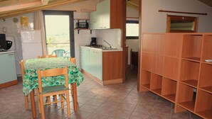Een kleine keuken met een eettafel, stoelen en een inbouwkast.