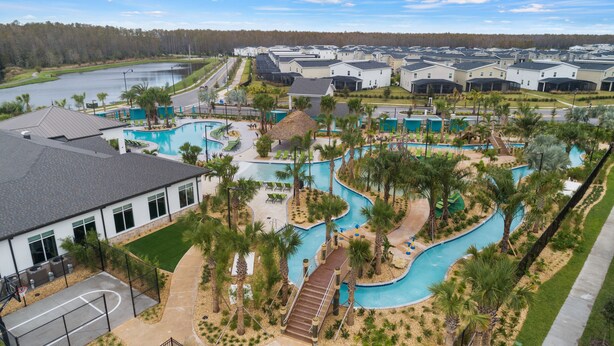 A residential area with multiple houses, a swimming pool, and a golf course in the background.