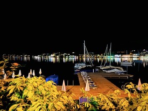 Relax by the marina with lounge chairs and umbrellas, surrounded by calm waters and city lights.