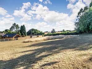 Propiedad rural con graneros, un área cercada y cielo despejado.
