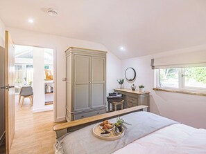 Um quarto com cama, mesa de cabeceira e vista para o exterior.