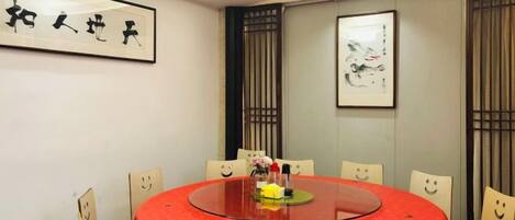 A conference room with a round table, chairs, and artwork on the walls.