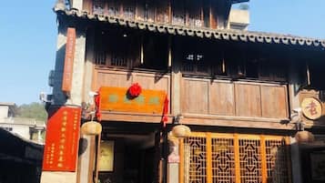 A traditional building with a wooden facade, a signboard, and a decorative gate.