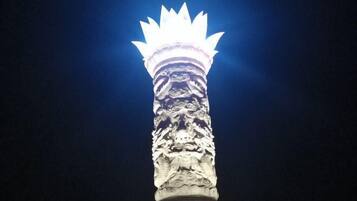 A tall, intricately carved column with a light at the top.
