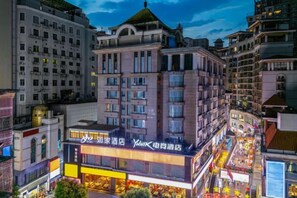 Un hotel de varios pisos con un letrero llamativo, rodeado de otros edificios.