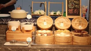 A buffet setup with various food items in wooden containers, a serving spoon, and a small dish with a spoon. - Homeinn · neo (Liuzhou Five Star Pedestrian Street) (Liuzhou)