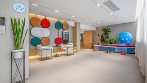 A modern lobby with a seating area, a reception desk, and a colorful wall decoration. - Homeinn · neo (Liuzhou Five Star Pedestrian Street) (Liuzhou)