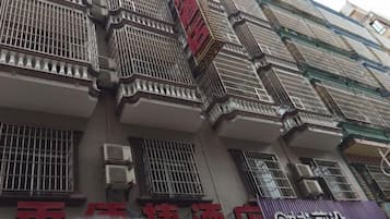 A multi-story building with balconies and air conditioning units.
