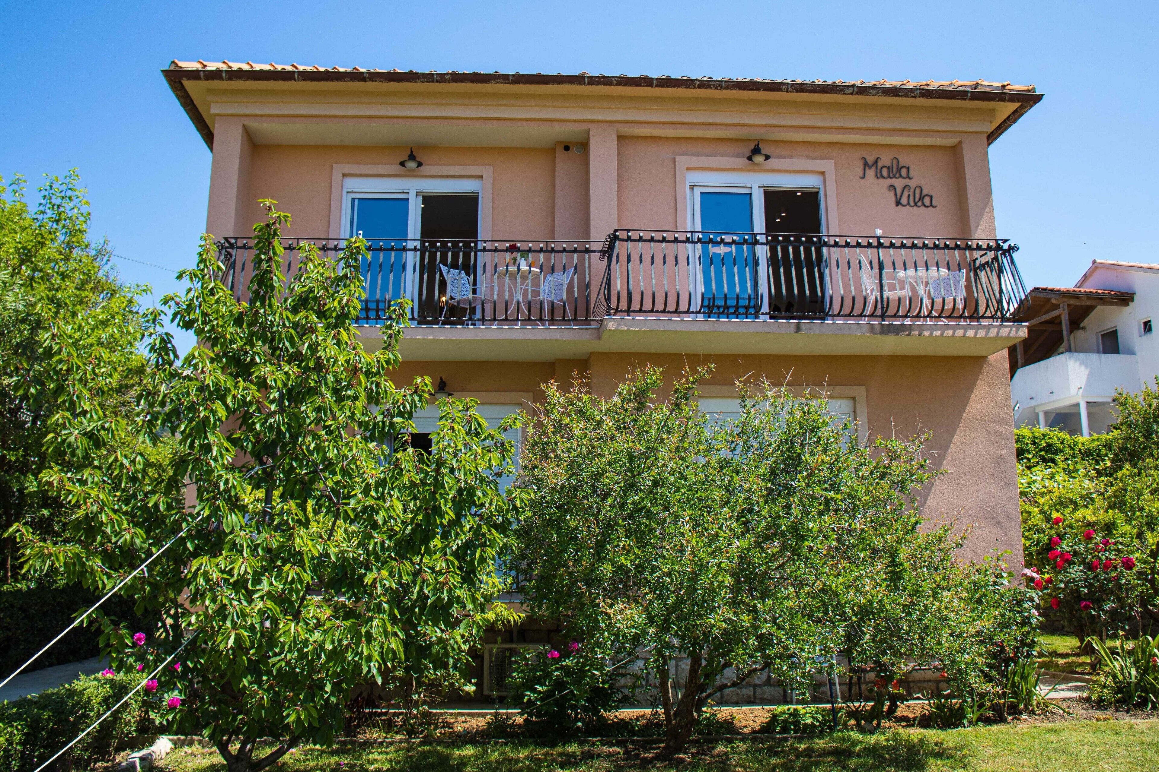 A two-story building named "Malla Villa" with a balcony on the upper floor.