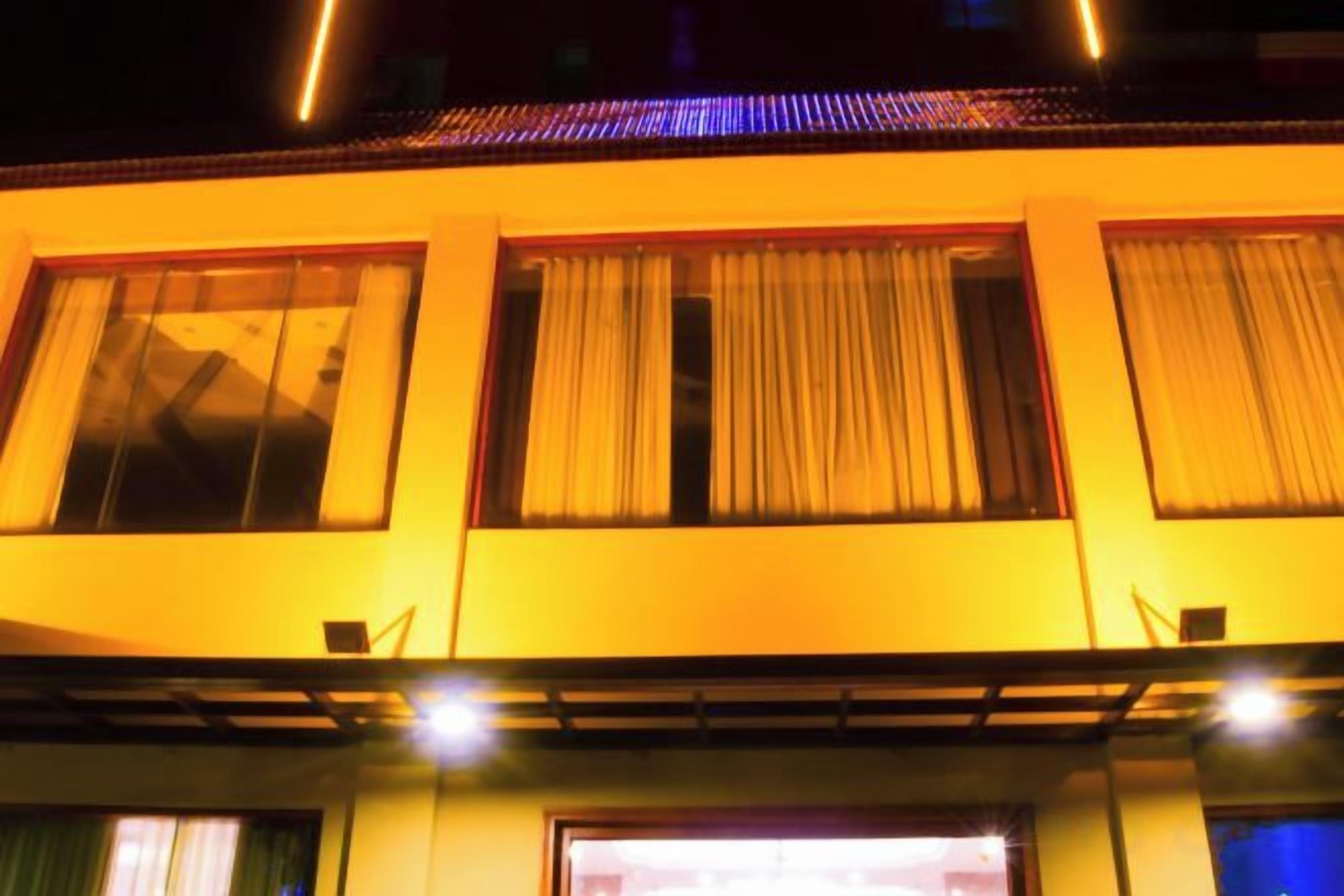 Fachada de edificio con varias ventanas, algunas con cortinas.