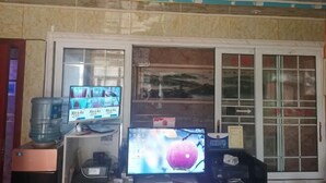 Una stanza con due monitor, un erogatore d'acqua e una scrivania piccola.