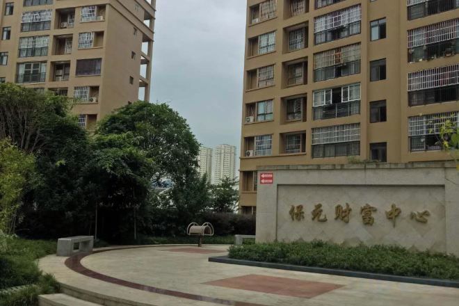 Un edificio residencial de varios pisos, una entrada con reja y un letrero con caracteres chinos.