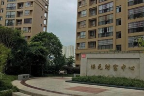 A residential building with multiple floors, a gated entrance, and a sign with Chinese characters. - Fuchuan Xingrong Theme Apartment (Wuchuan)