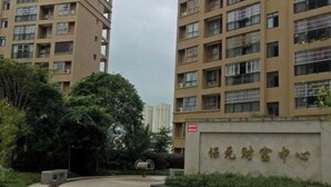 Un edificio residenziale con diversi piani, un cortile centrale e un cartello con caratteri cinesi.