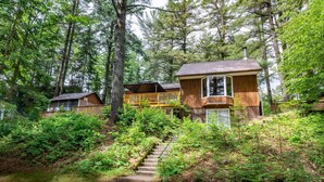 Une zone boisée avec des chalets en bois dotés de balcons et d’un escalier menant à ceux-ci.