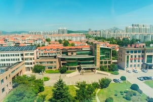 Un campus con varios edificios, un patio central y un estacionamiento.