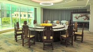 A conference room with a round table, eight chairs, and a large window offering a view of greenery. - Yintan Hotel (Rushan)