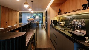 Eine moderne Küche mit Holzelementen, einer langen Arbeitsplatte und Blick in einen Essbereich.
