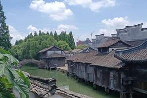 Des bâtiments traditionnels en bois, avec une rivière et un pont.