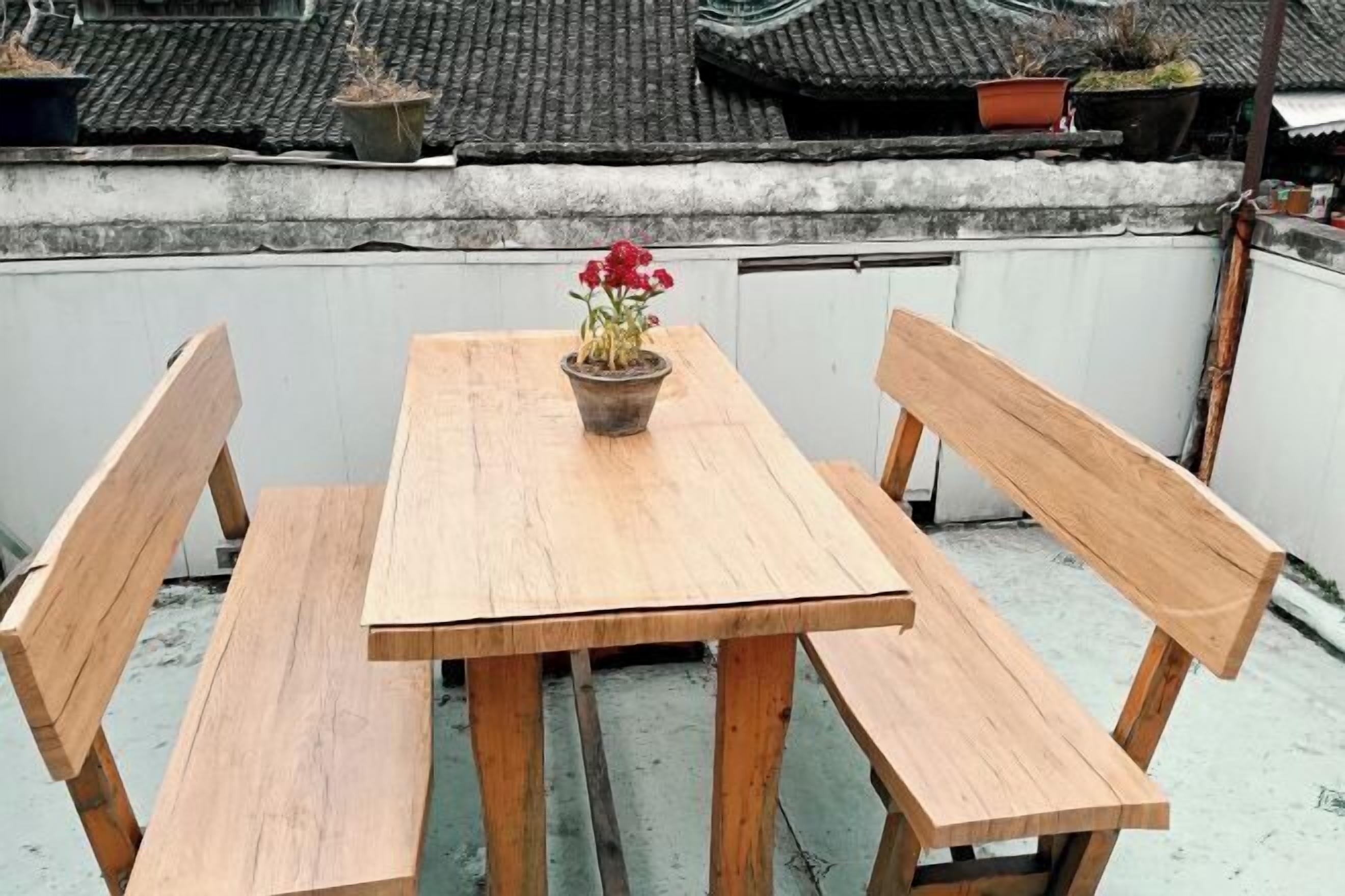 A wooden table with benches on a rooftop terrace.