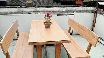 A wooden table with benches on a rooftop terrace.