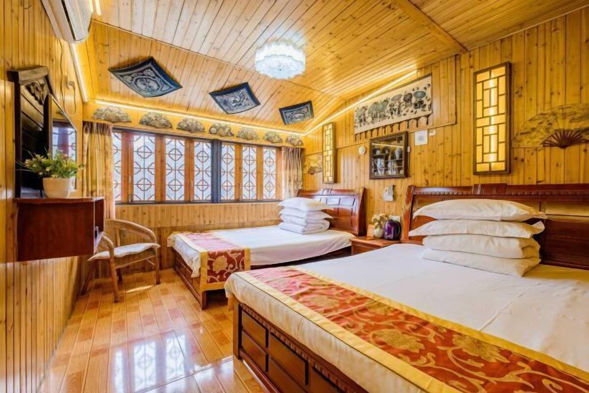 Una habitación de madera con una cama, una silla y un escritorio.