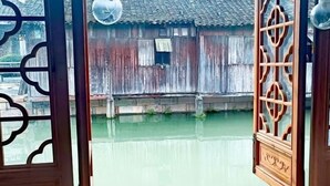 Un bâtiment traditionnel en bois, doté d’un toit en tuiles et d’une porte en bois ornée de sculptures complexes.
