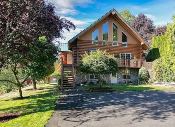 Experience the charm of a rustic retreat in this cozy cabin-style building surrounded by a lush lawn and trees.