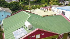 Un edificio con techo verde, toldo rojo y un letrero que dice "Cays Inn".