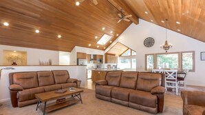 A spacious living room with two brown leather sofas, a wooden coffee table, and a ceiling fan. - 10 SHARC/basketball ct/ac/private hot tub+bikes +snow sleds (Sunriver)