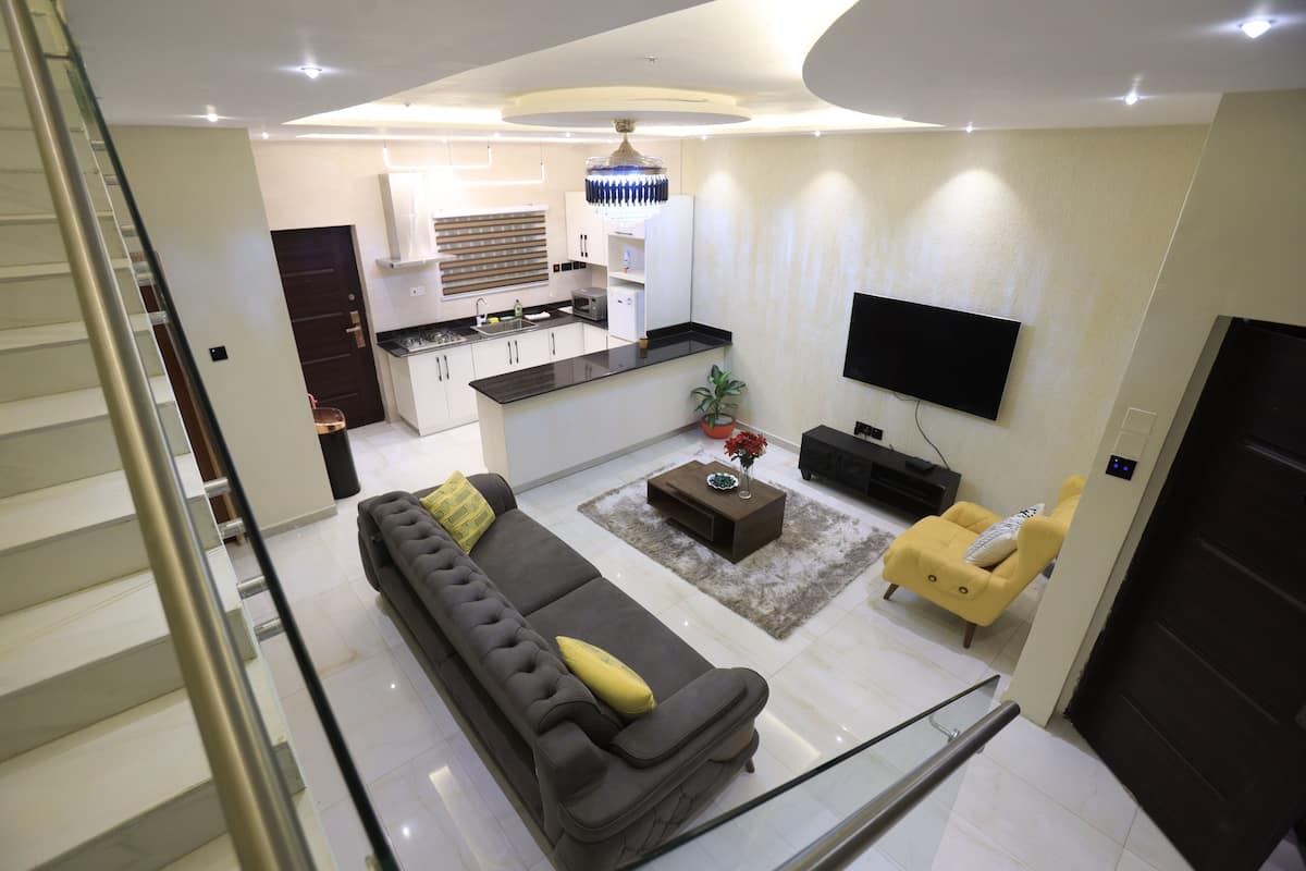 Una sala de estar moderna con un sofá, una mesa de centro y un televisor montado en la pared.