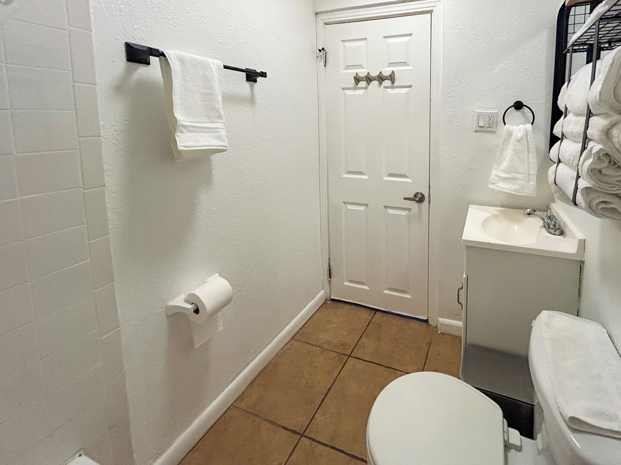 Ein Badezimmer mit Toilette, Waschbecken und Handtuchhalter.